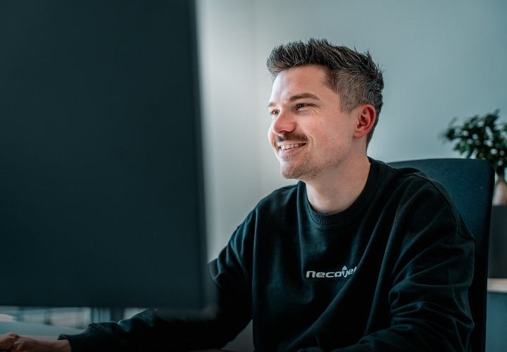 Techniker in Beratung am PC zu sehen lächelnd in den Bildschirm schauend